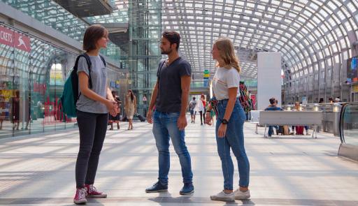 un ragazzo e due ragazze in una stazione ferroviaria