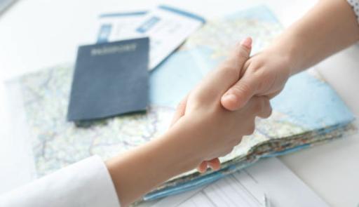 due mani che si stringono e un passaporto sullo sfondo