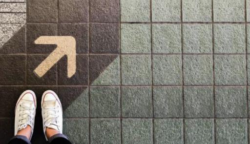 piedi su un pavimento dove è raffigurata una freccia