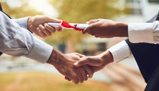 due mani sinistre che si stringono, mentre una mano destra consegna un diploma in un'altra mano