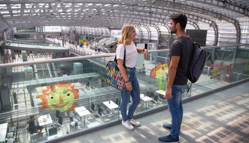 Ragazzo e ragazza in attesa alla stazione ferroviaria di Torino Porta Susa