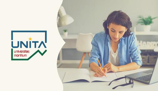 smiling girl writing in a notebook sitting at a table