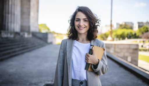 immagine di una ragazza sorridente con un libro in mano