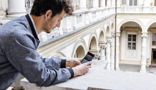 Studente che utilizza il tablet sul loggiato del Palazzo del Rettorato